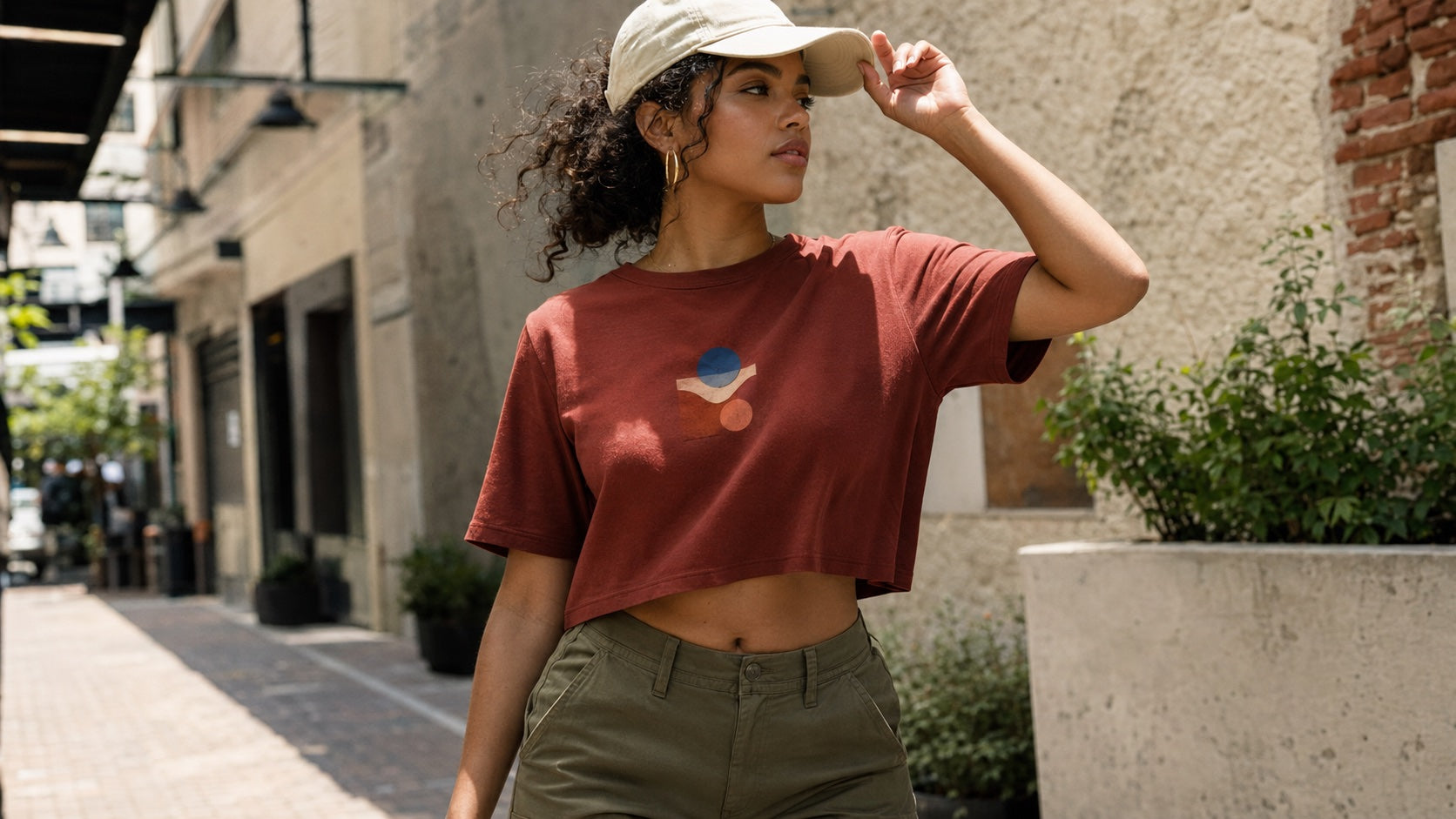 Woman wearing a cropped streetwear tee and cap